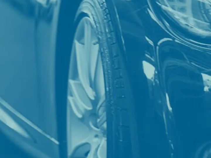 Close crop of a car wheel arch and alloy wheel